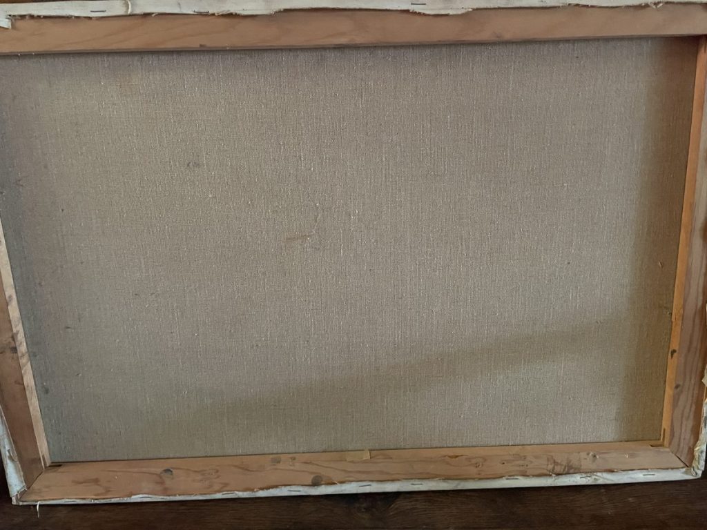 The back view of a framed canvas artwork showing the wooden frame and fabric backing.