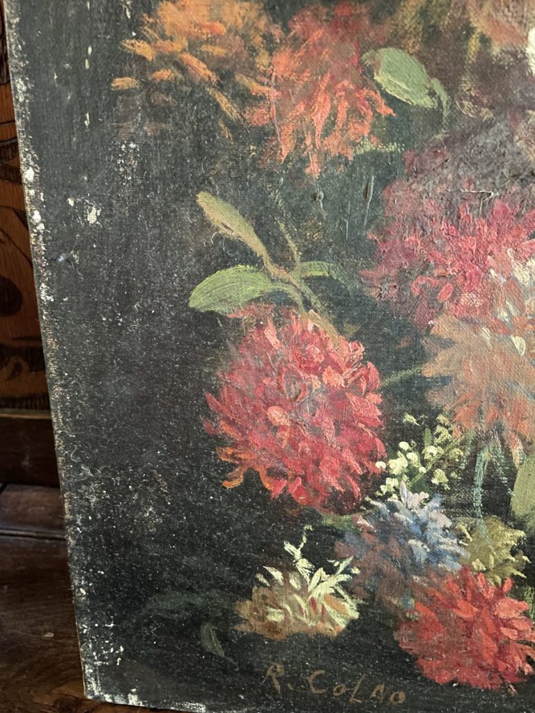 Close-up of a floral still life painting featuring red and pink flowers with green leaves.