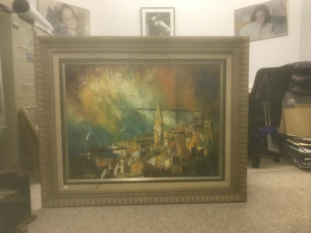 Framed abstract painting featuring vibrant colors and a cityscape with a clock tower.