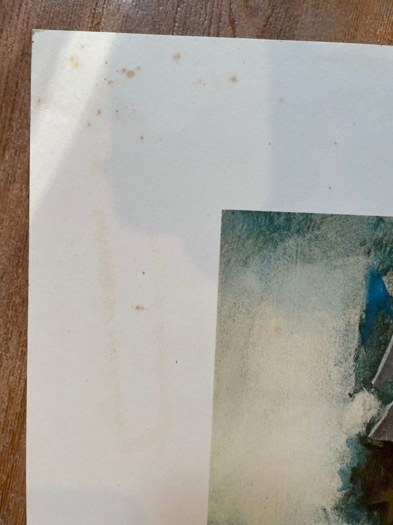Close-up of a watercolor painting showing stains on the paper surface.
