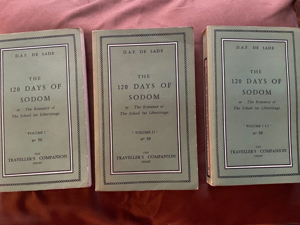 Three volumes of 'The 120 Days of Sodom' by D.A.F. de Sade displayed together.