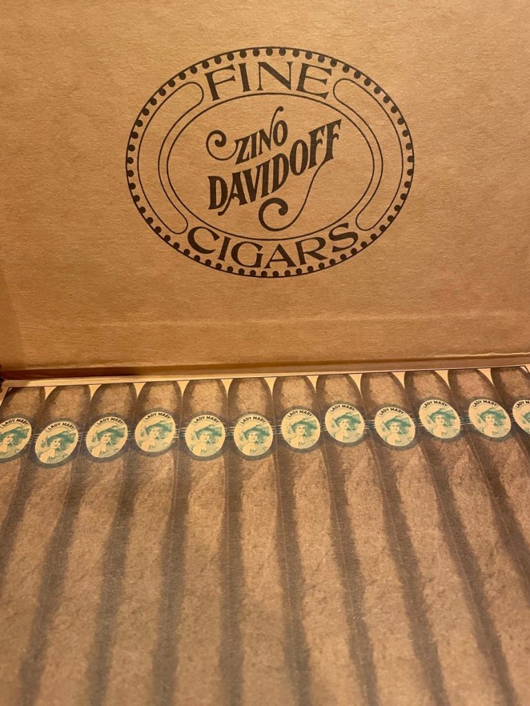 Open box of Zino Davidoff fine cigars with a logo and cigars lined up inside.