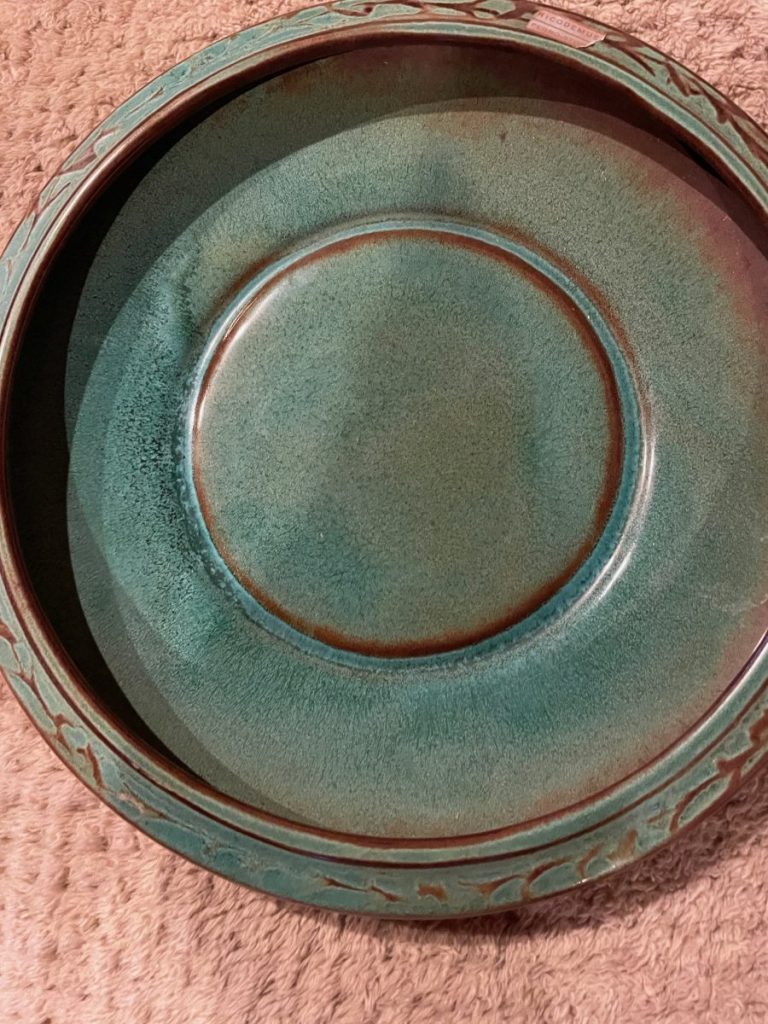 Ceramic plate featuring a green glaze with a textured rim design.