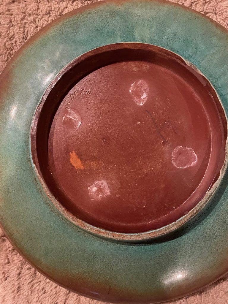 Ceramic bowl featuring a green glaze finish and a brown interior base.