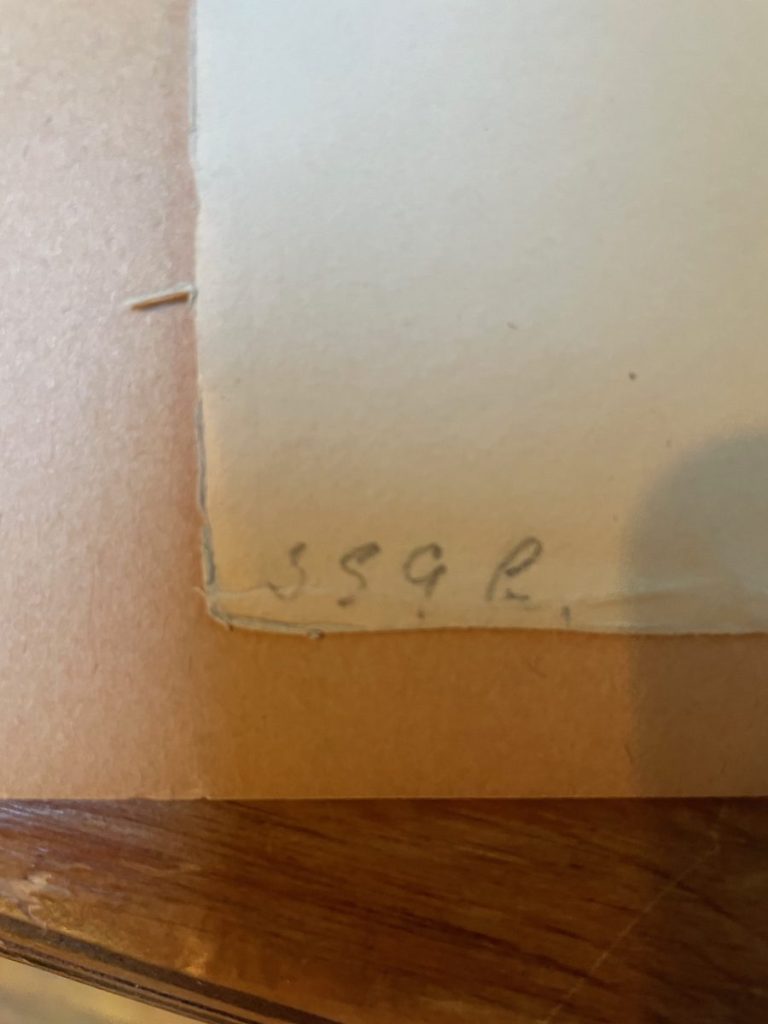 A close-up view of a handwritten number '359' on a piece of paper with a light brown background.