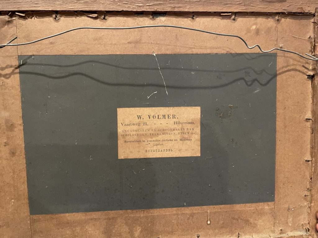 The back of a framed artwork featuring a label with the name W. Volmer and address details.