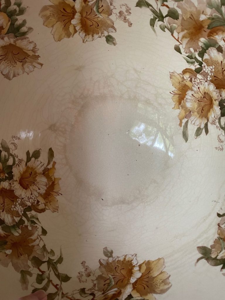 Decorative bowl featuring a cream background with floral patterns in shades of yellow and brown.