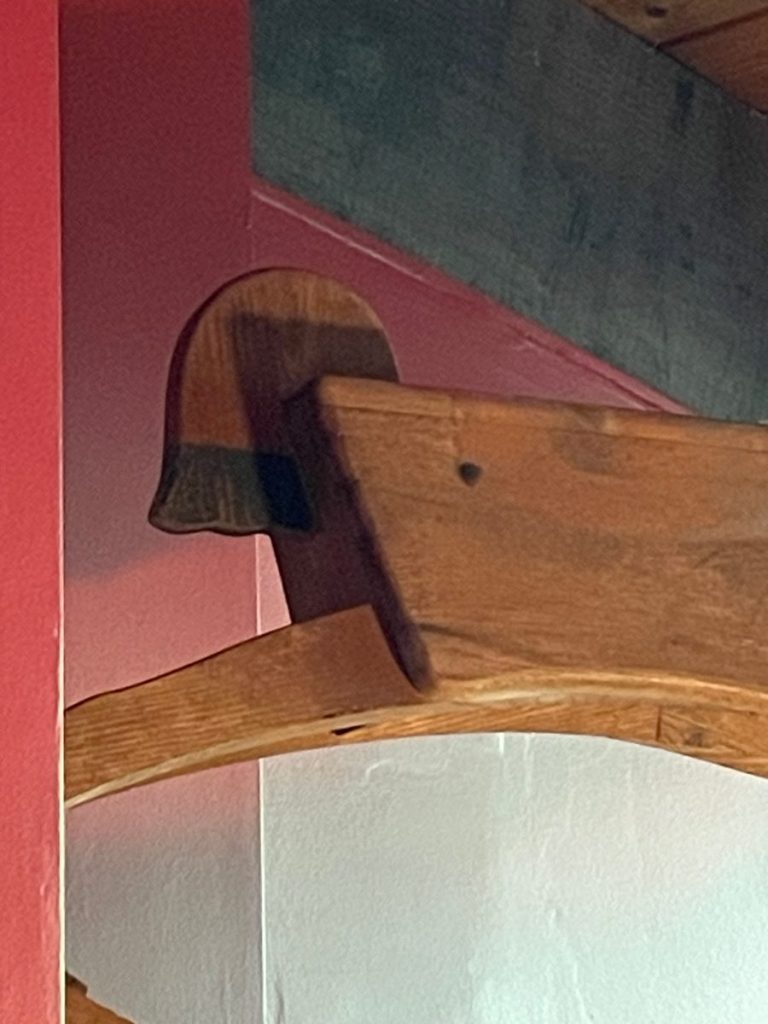 Wooden shelf bracket featuring a distinctive silhouette design mounted on a wall.