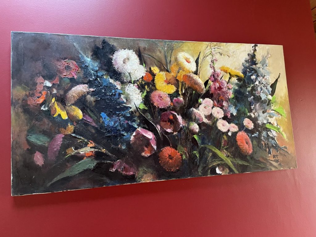 A vibrant still life painting featuring a variety of colorful flowers arranged in a bouquet.