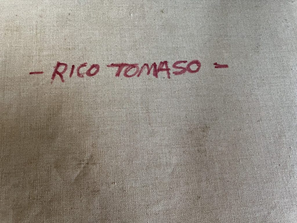 Handwritten signature of Rico Tomaso in red ink on a beige canvas surface.