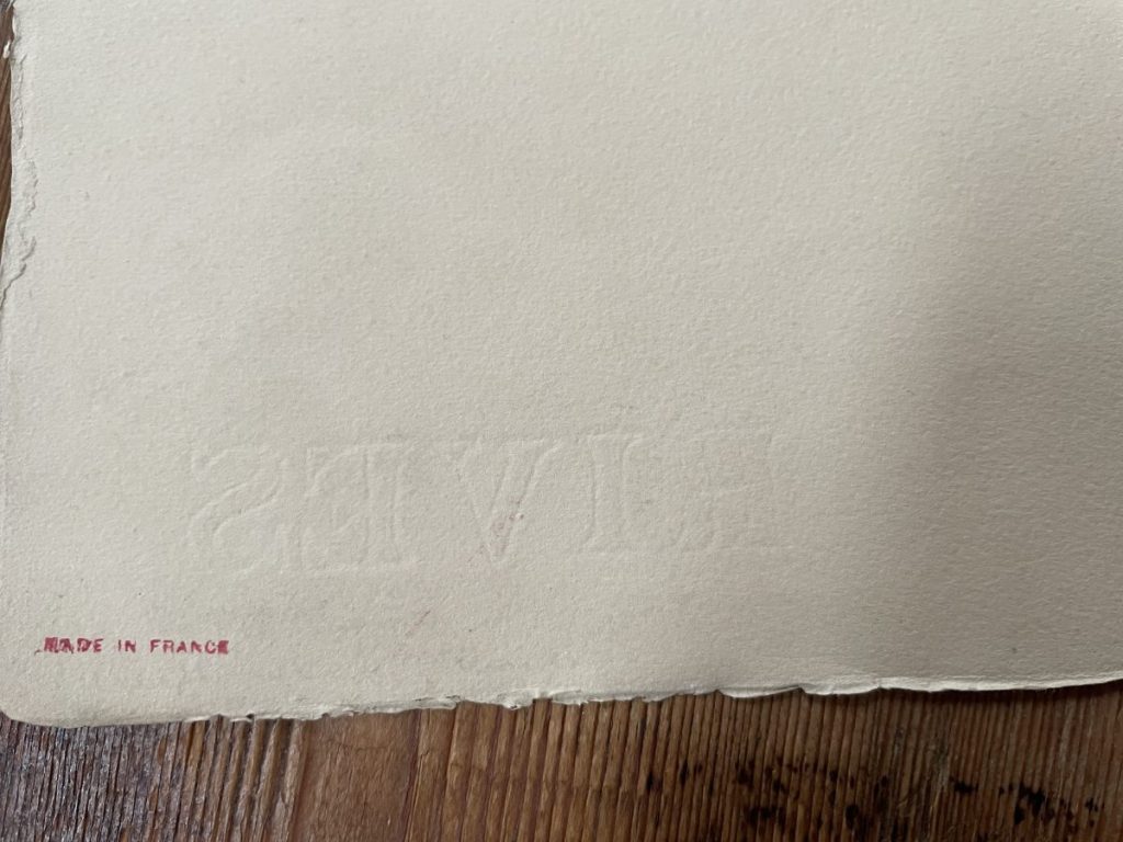 Embossed paper featuring the word 'LIVES' and 'Made in France' printed in red ink.