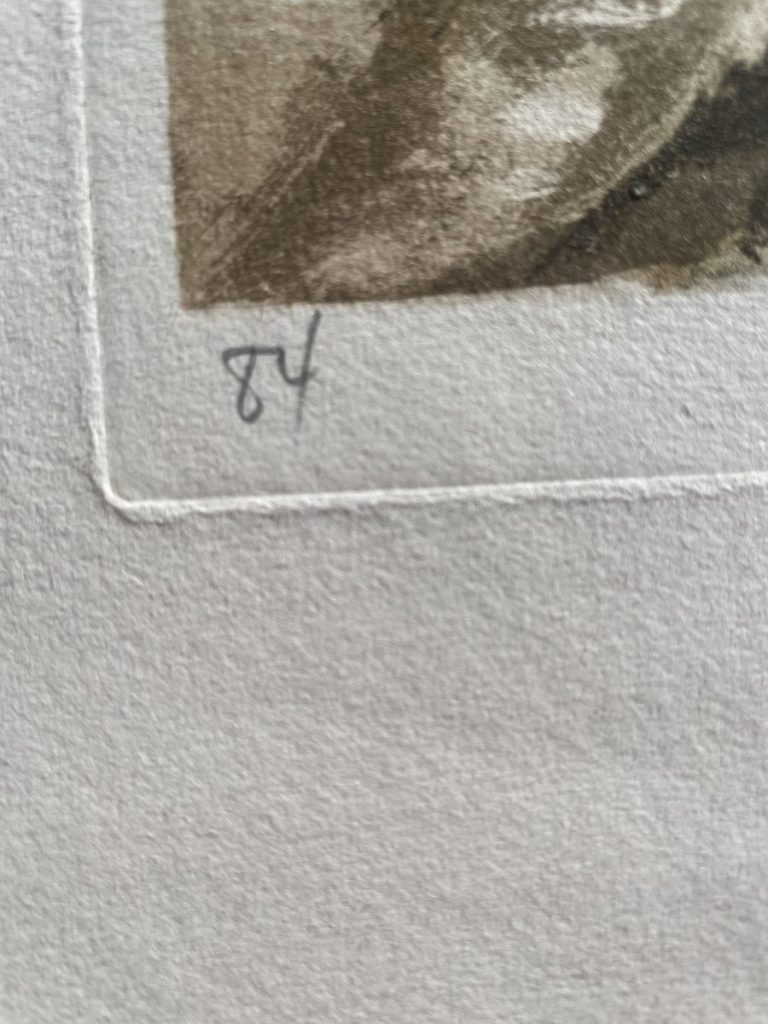 Close-up of a numbered detail on an artwork, showing the number 84 written in pencil.