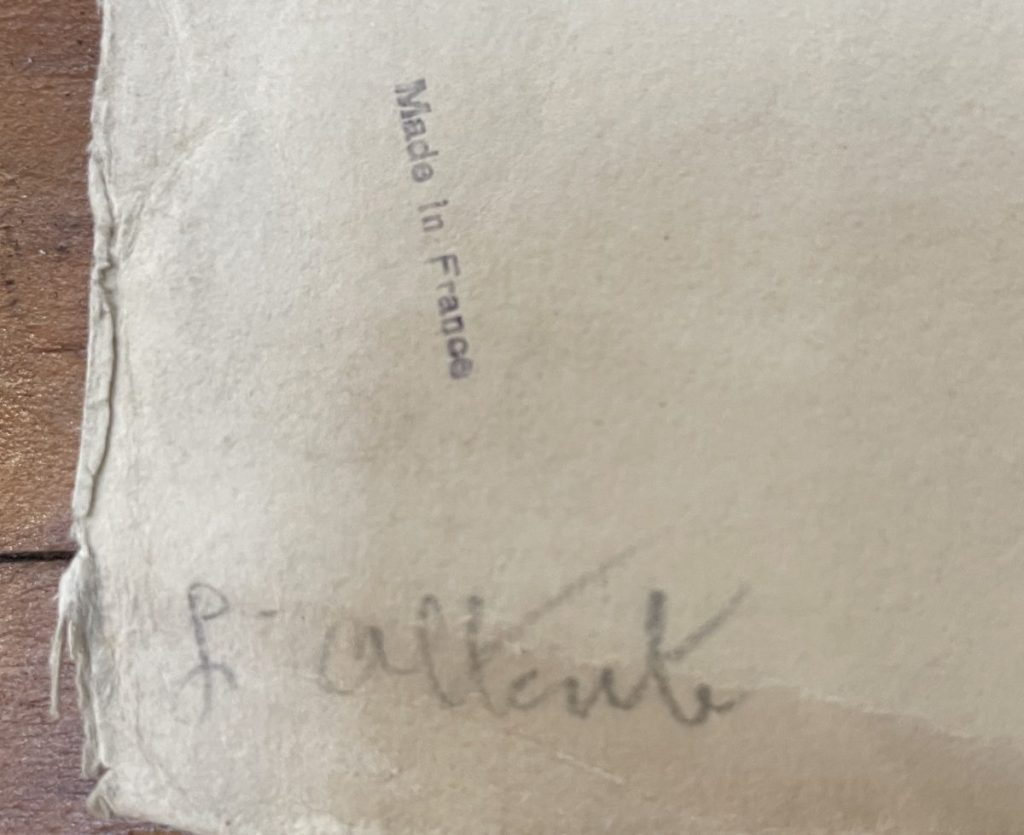 Close-up of a paper showing a handwritten signature and a label stating 'Made in France'.