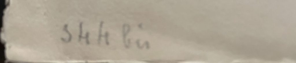 Close-up of an artist's signature on a piece of artwork, written in pencil.