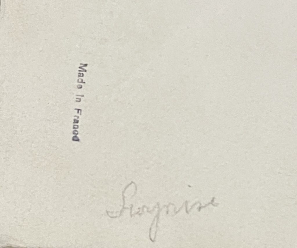 Text printed on a piece of paper indicating 'Made in France' and a handwritten signature.