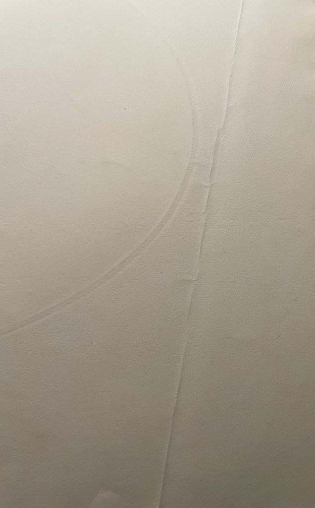 Close-up of a textured white paper surface with subtle lines and creases.