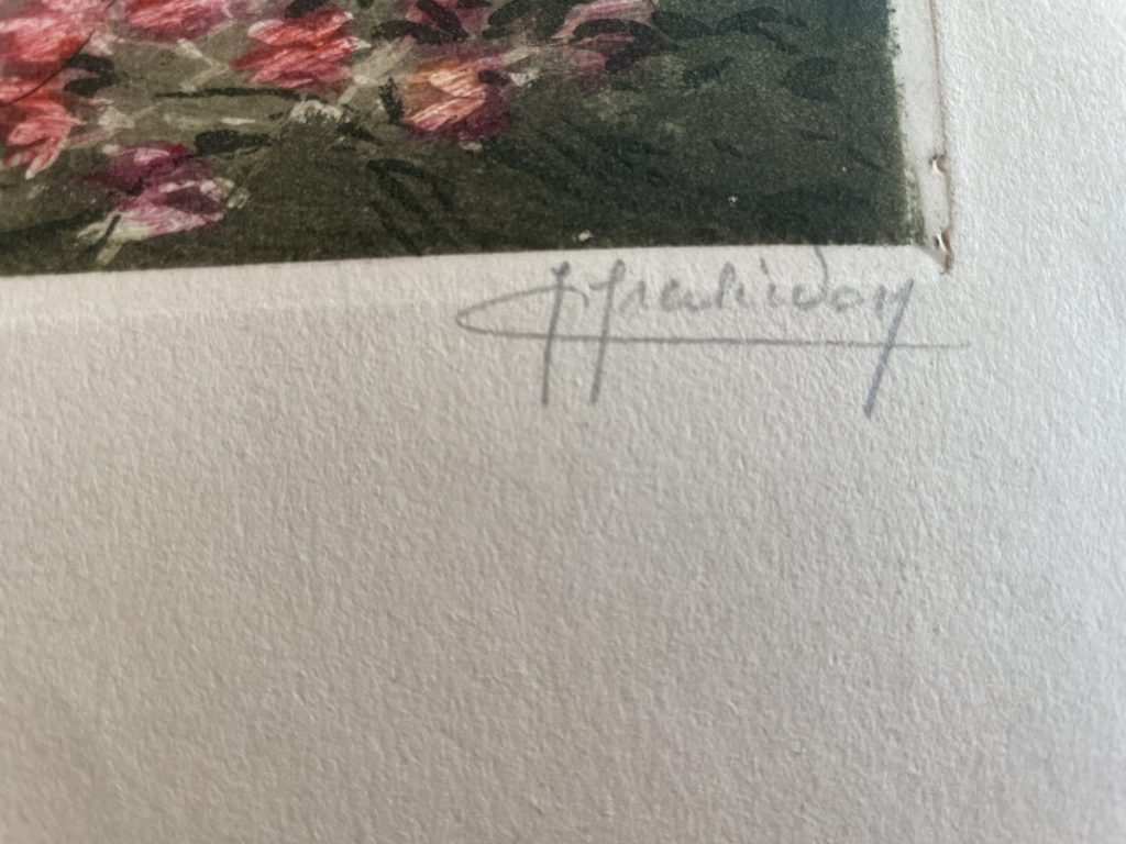 Close-up of an artist's signature in pencil on a textured paper surface.